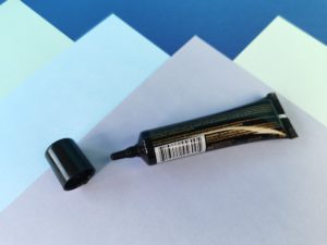 De tube ligt, je ziet de achterkant. Het dopje is er af,