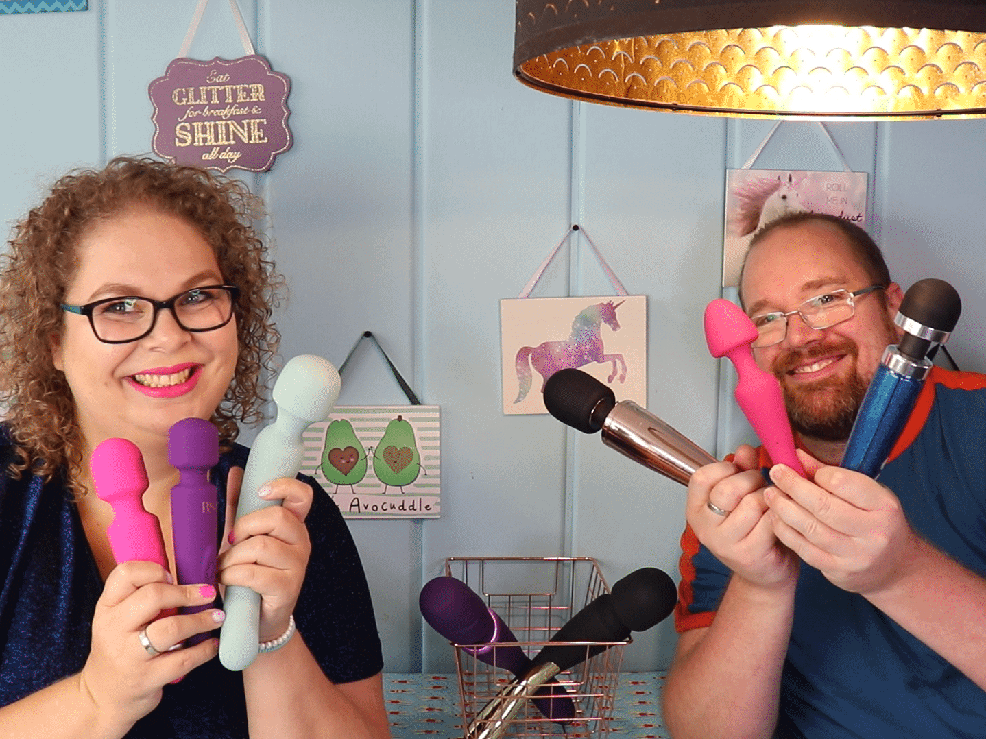 Tess en Jay zitten aan de keukentafel en ze houden allebei drie wand vibrators vast en kijken blij.