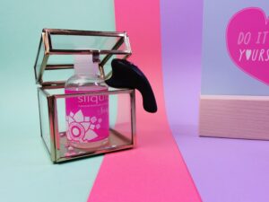 De fun factory be one hangt tussen de opening van het glazen kubus doosje.