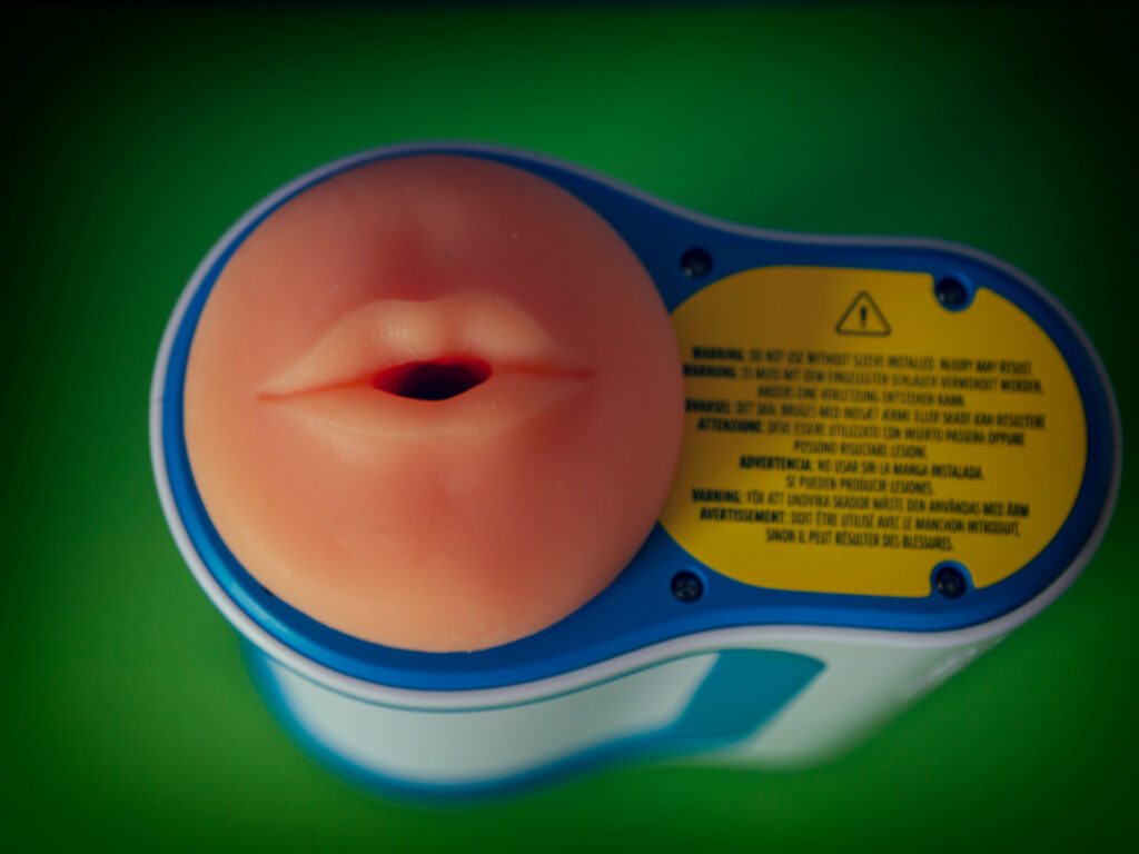 Bovenaanzicht van de autoblow ai je ziet de mondopening van de sleeve en een sticker die je meld dat je de autoblow niet zonder sleeve kan gebruiken omdat je anders je lichaam beschadigd
