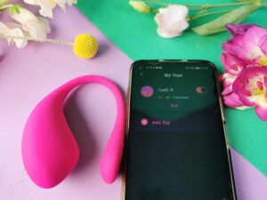 De lovense lush 3 naast een telefoon die connectie heeft met de toy.