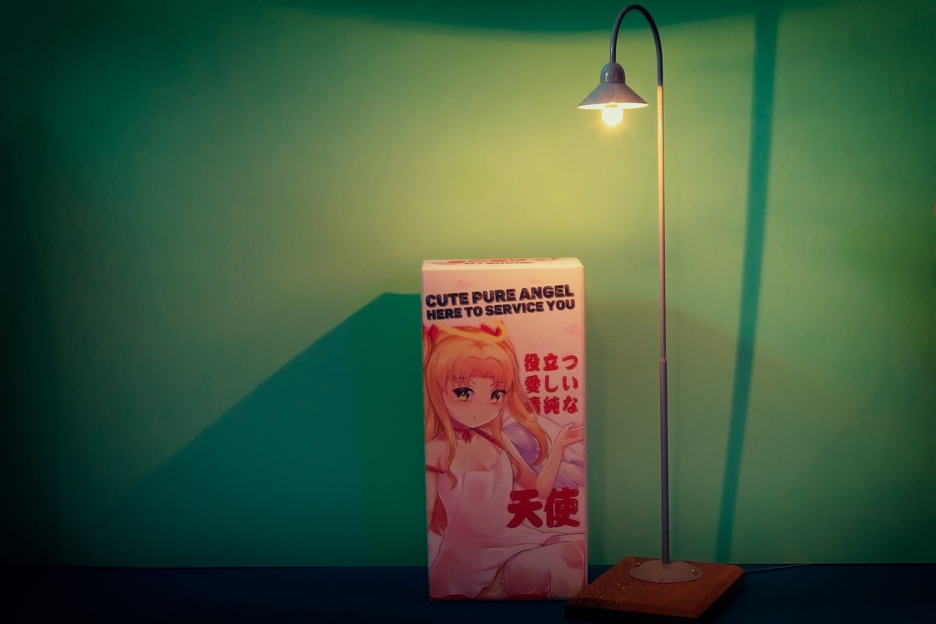 Slut Angel van XTC toys, je ziet hier een foto van de doos van deze masturbator onder een model straatlamp