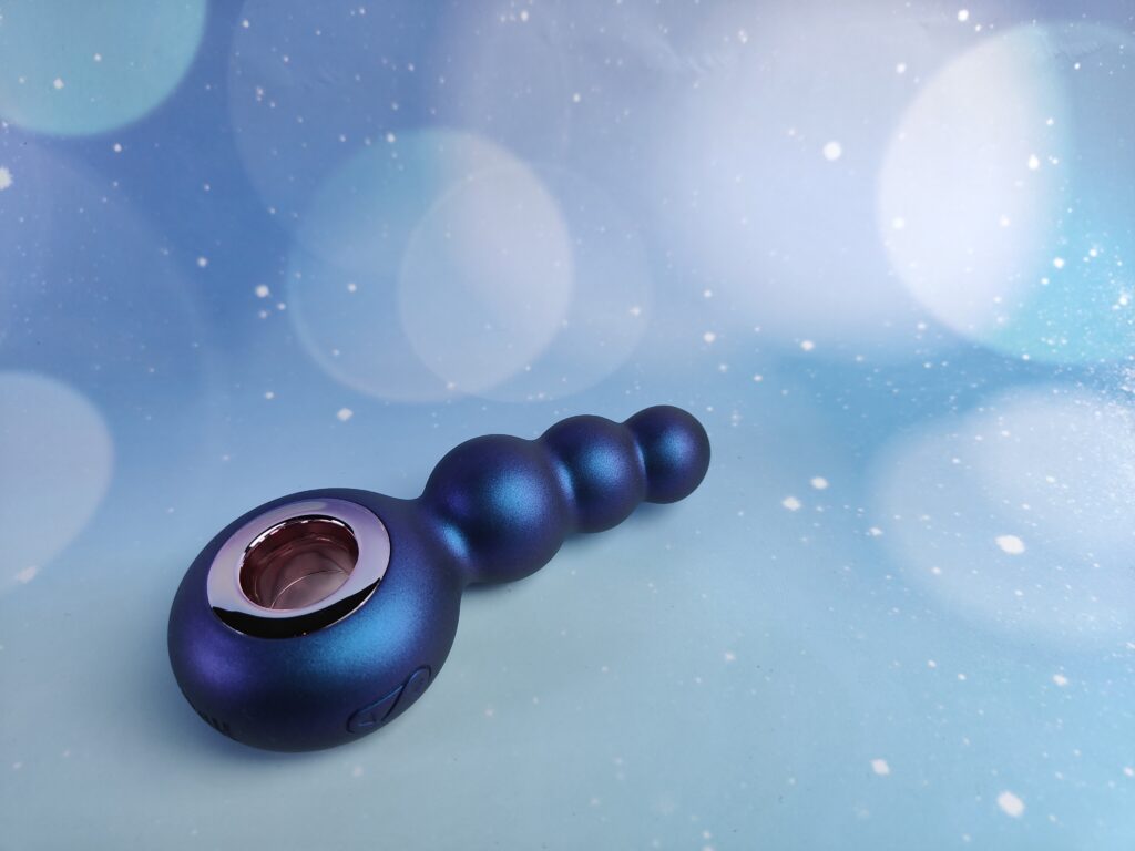 De hueman outer space vibrerende buttplug op een blauw achtergrondje.