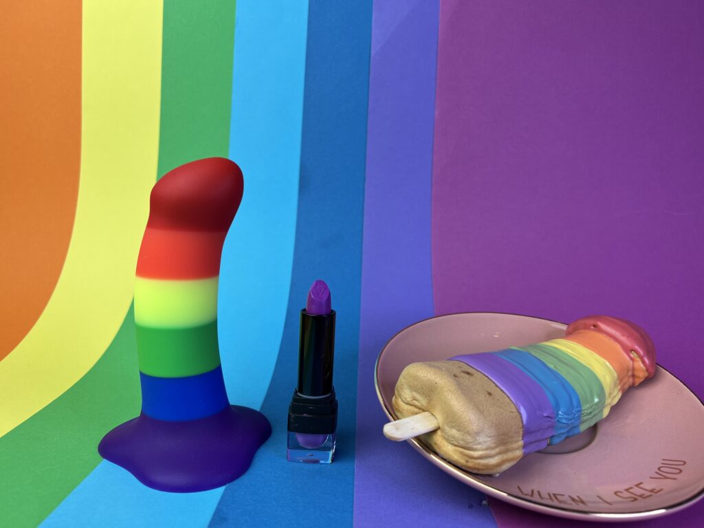 The fun factory amor pride next to a lipstick