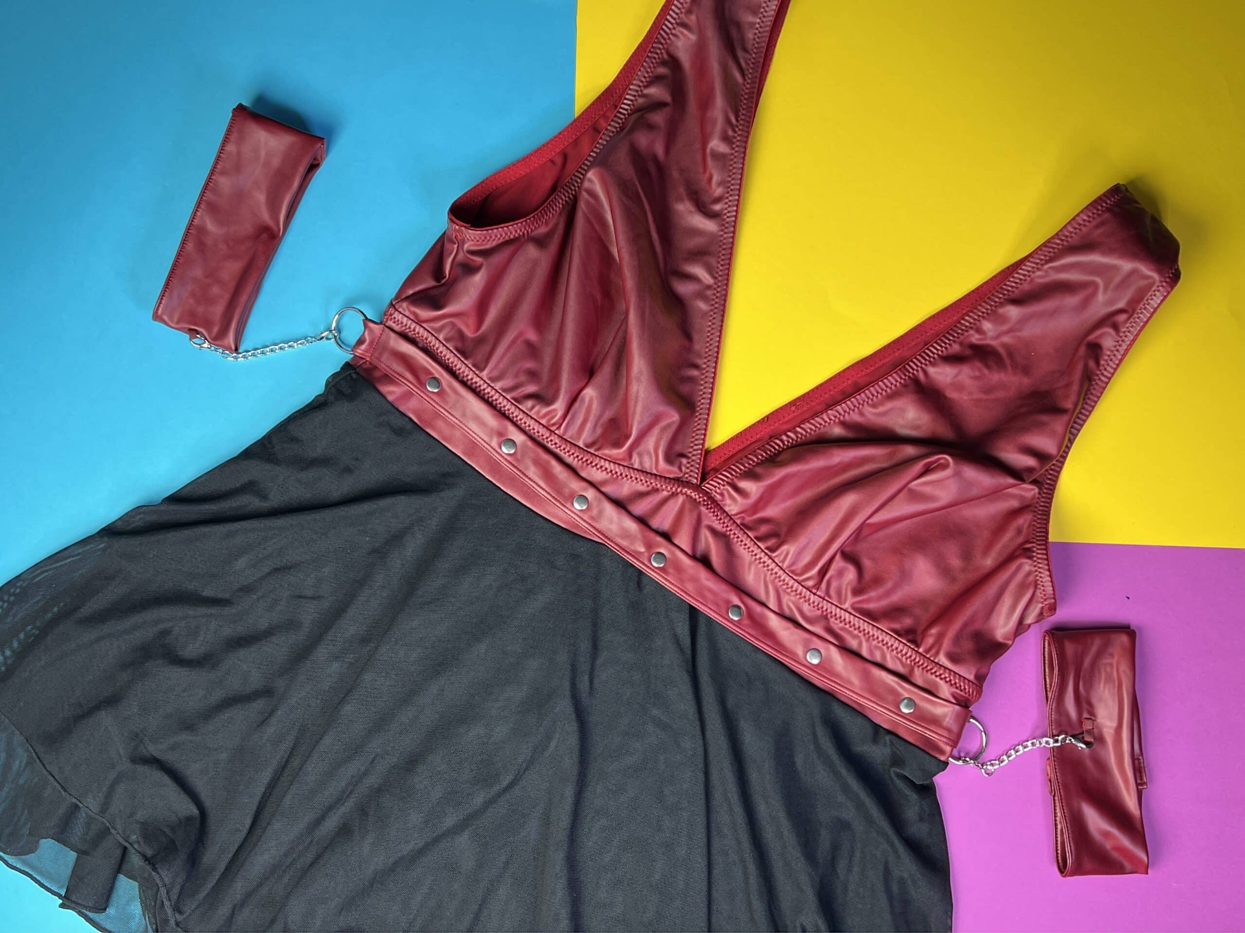 De Cottelli Bondage Plus Babydoll is aan de bovenkant rood en aan de onderkant zwart. In de taille zitten twee kettinkjes met daaraan armbanden die ook rood zijn.