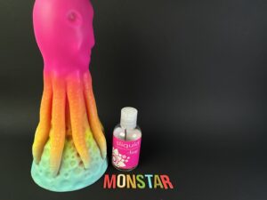 De kiotos monstar dildo beast no. 54 naast een flesje sliquid glijmiddel.