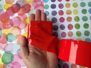 Het rode bondage tape om mijn hand.