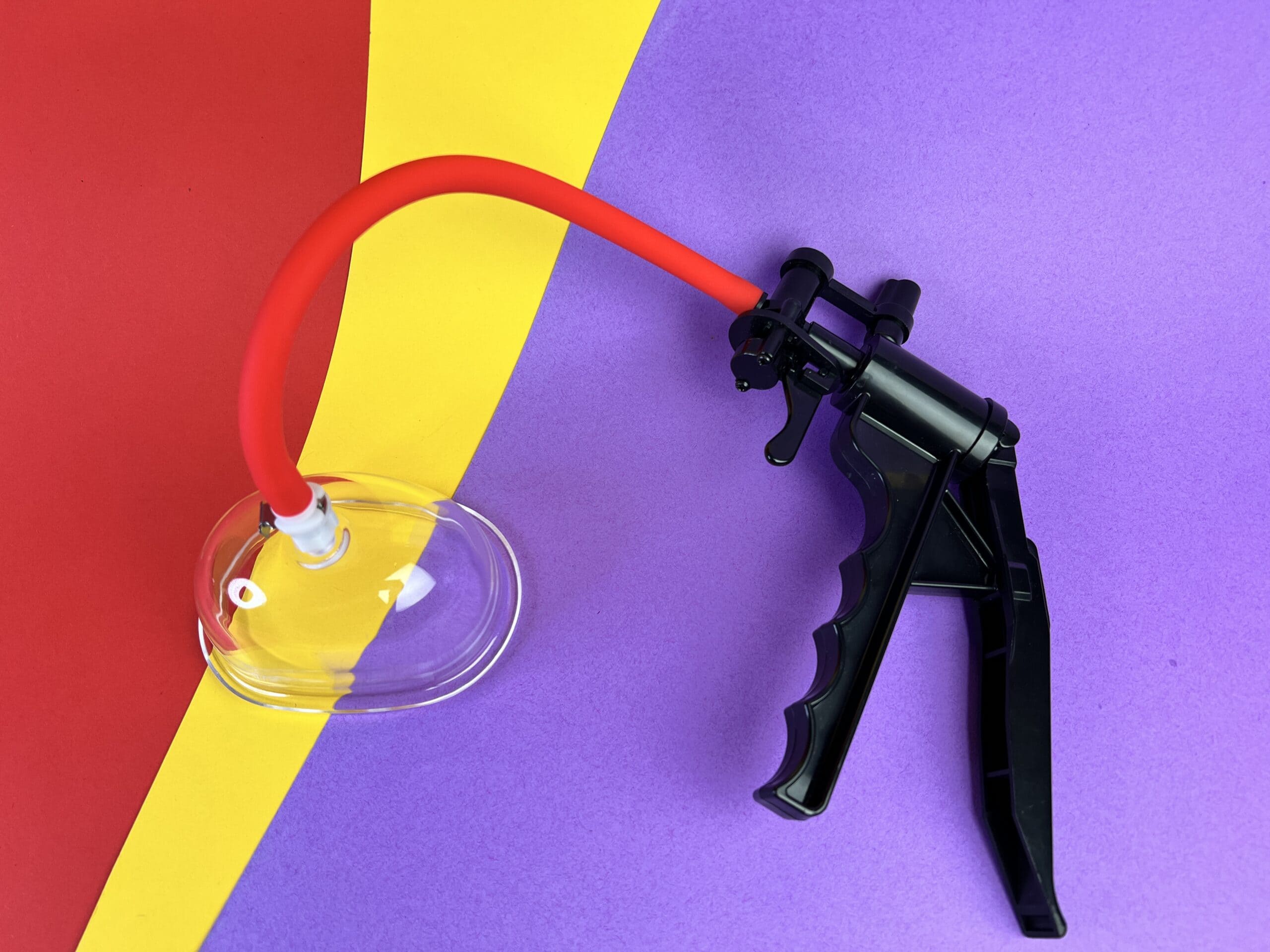 Het Temptasia Advanced Pussy Pump System op een gekleurd ondergrondje.