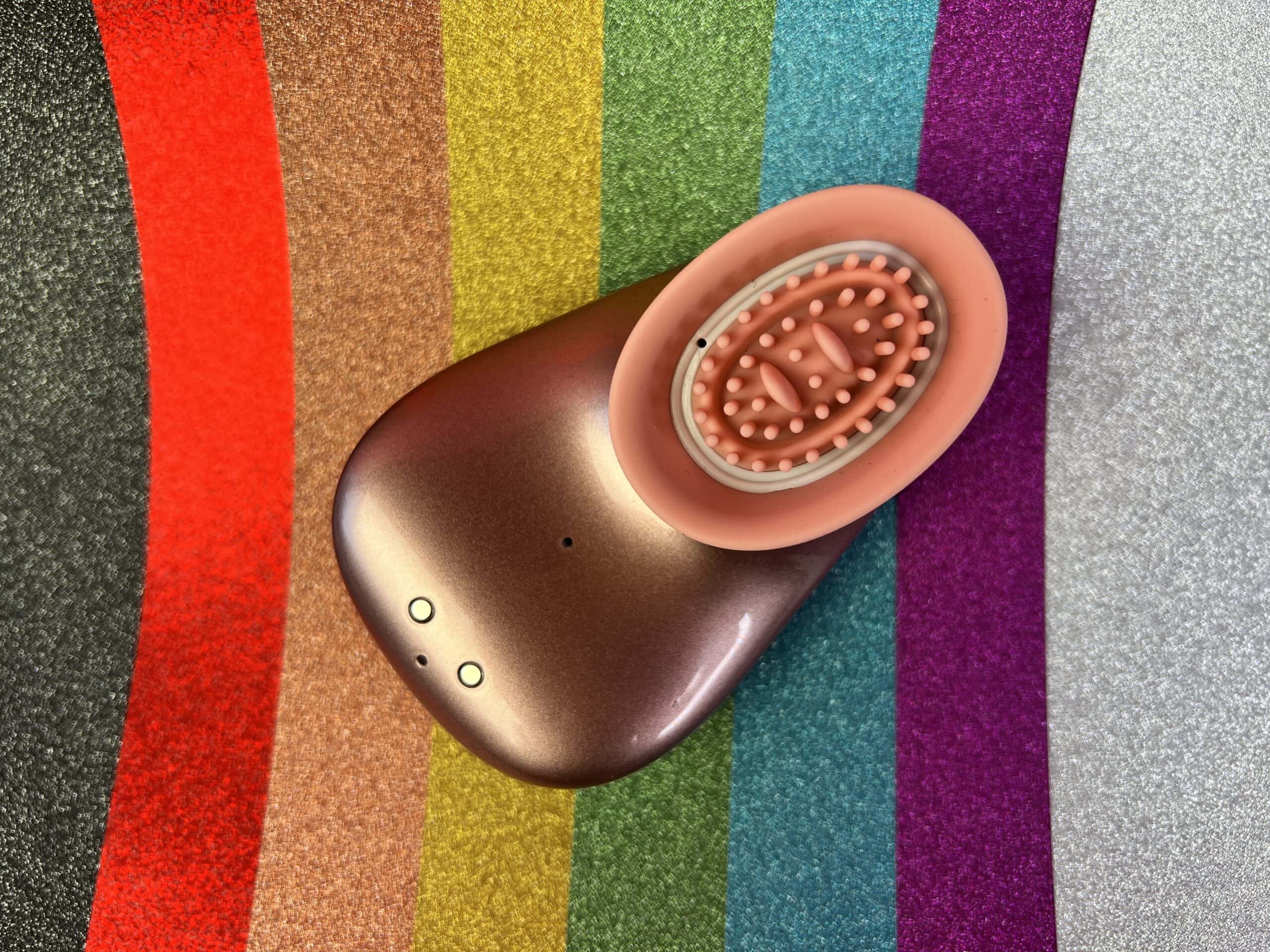 De Innovation Twitch ligt op z'n rug op gekleurd glitter regenboog papier.