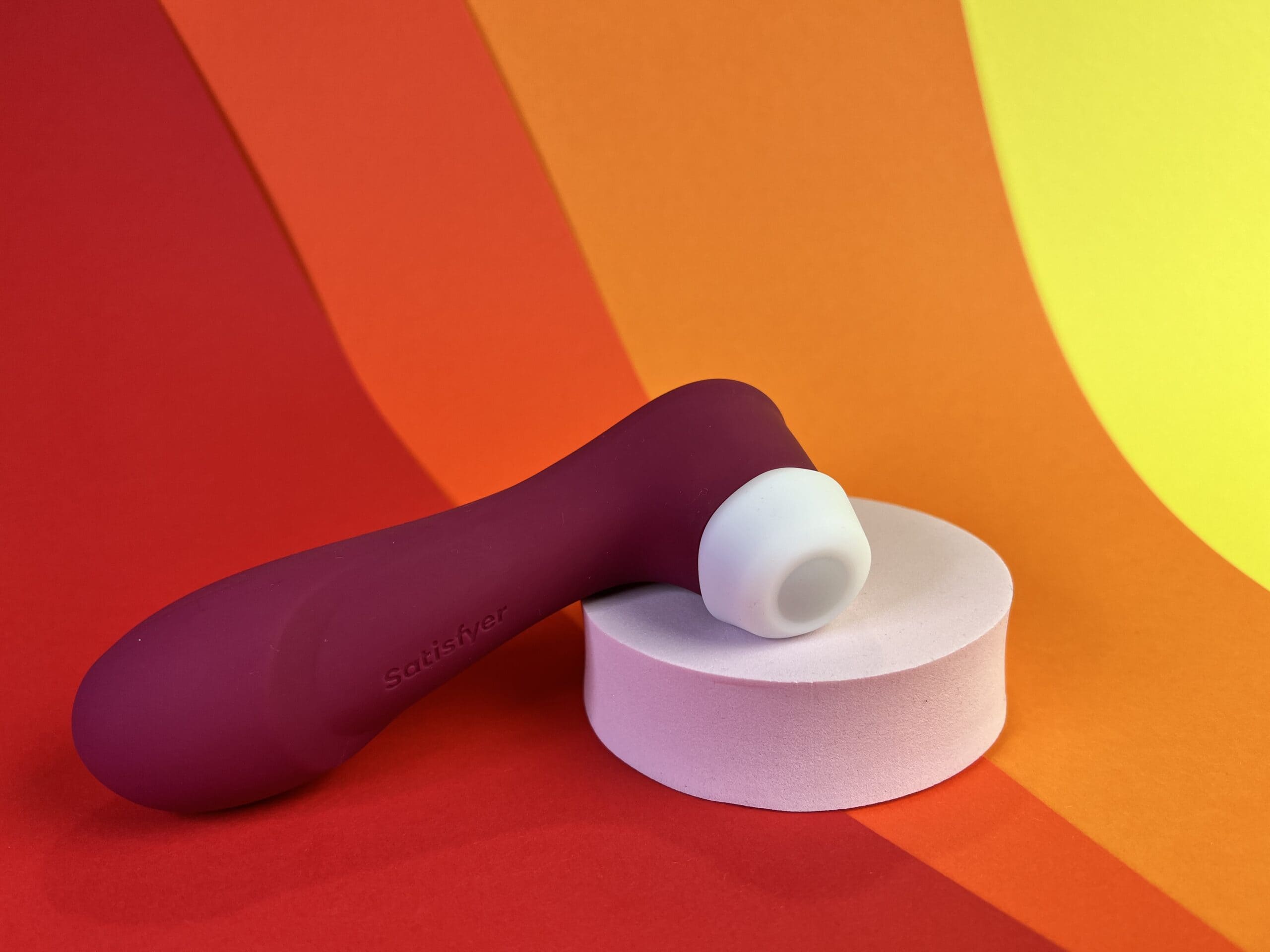 De Satsifyer Pro 2 Generation 3 met Liquid Air Technology op een rood oranje geel ondergrondje.