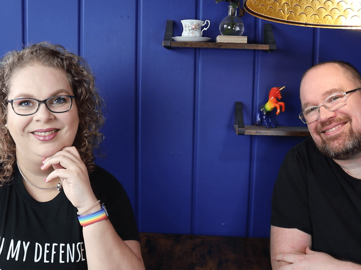 Tess en Jay zitten aan de keukentafel en kijken blij.