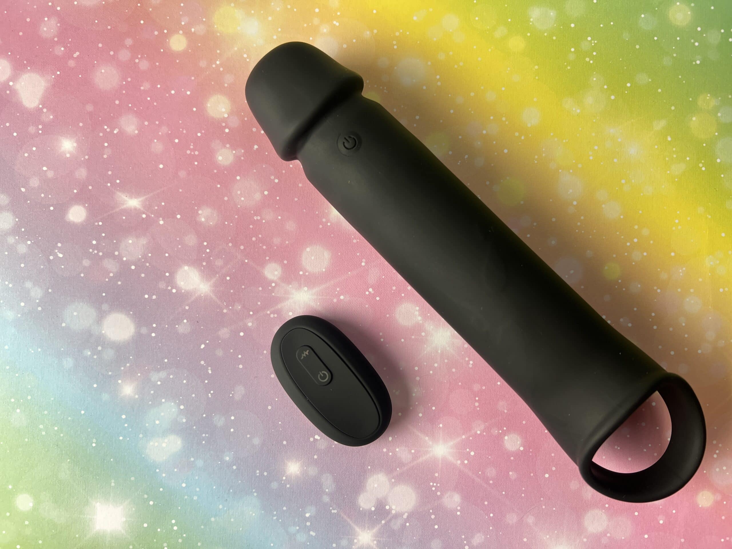 De Mr. Member Power Vibrating Penis Sleeve op een regenboog met sterren achtergrondje.