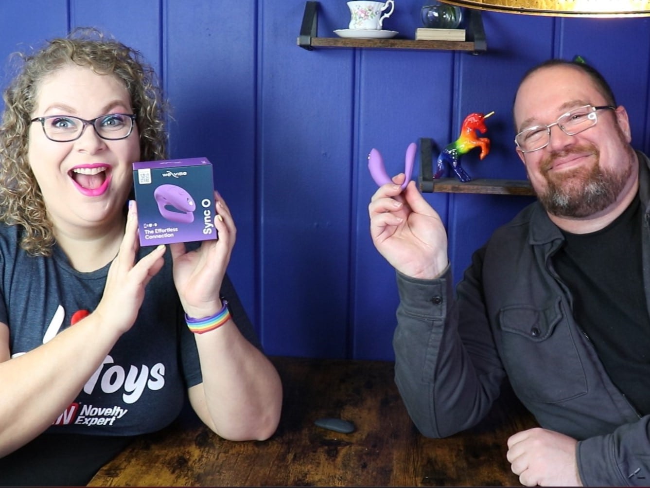 Tess en Jay zitten aan de keukentafel. Tess houdt de verpakking vast en Jay de Sync O zelf.