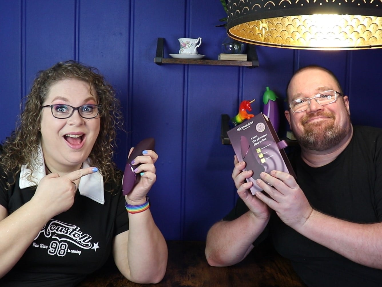 Tess en Jay zitten aan de keukentafel. Tess houdt de Womanizer Next vast en Jay de verpakking.