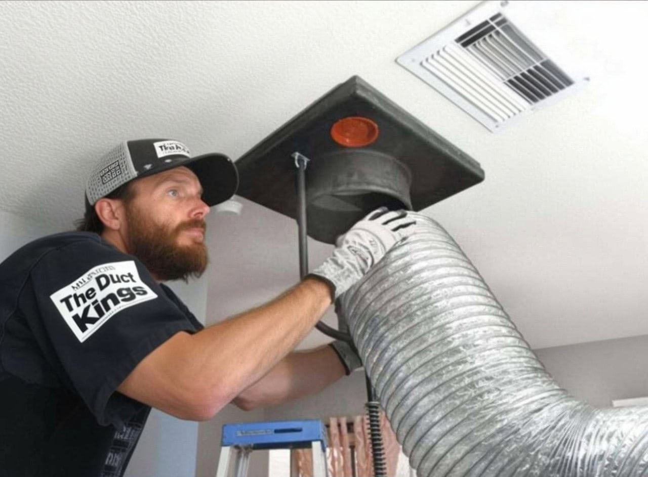 Professional duct cleaning service inspecting an air vent on ceiling.