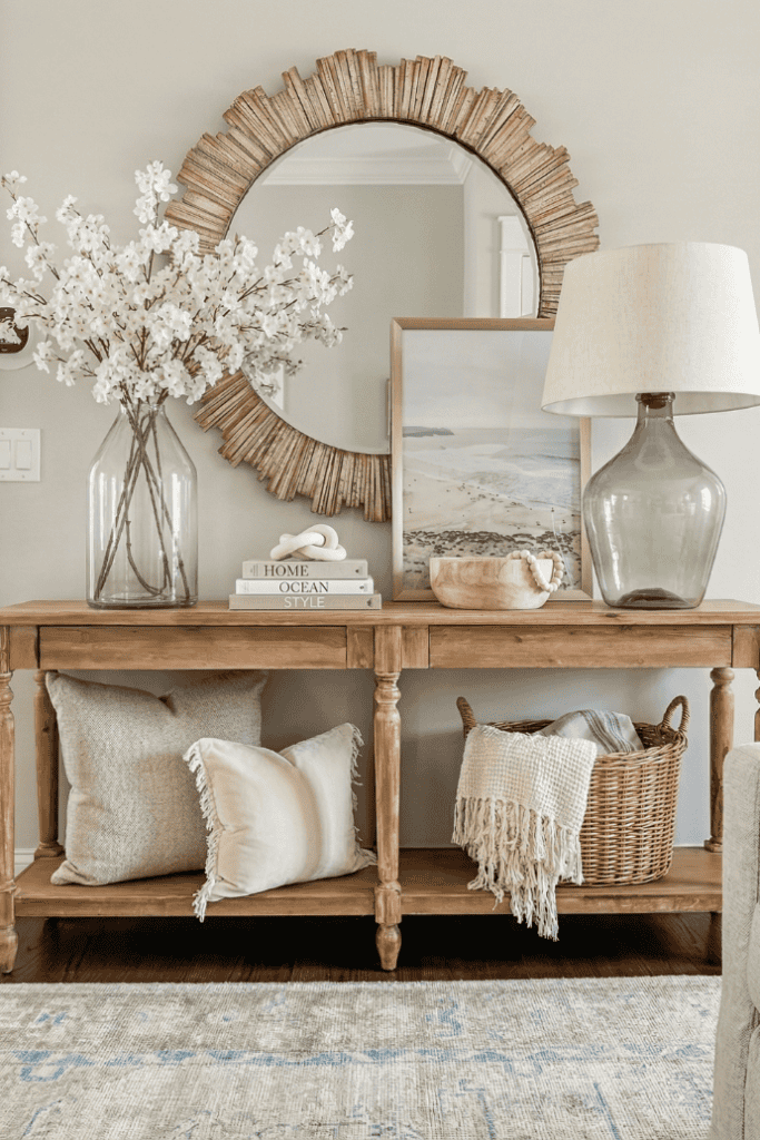 Living room console table decor with flowers, mirror, and lamp for stylish home accents.