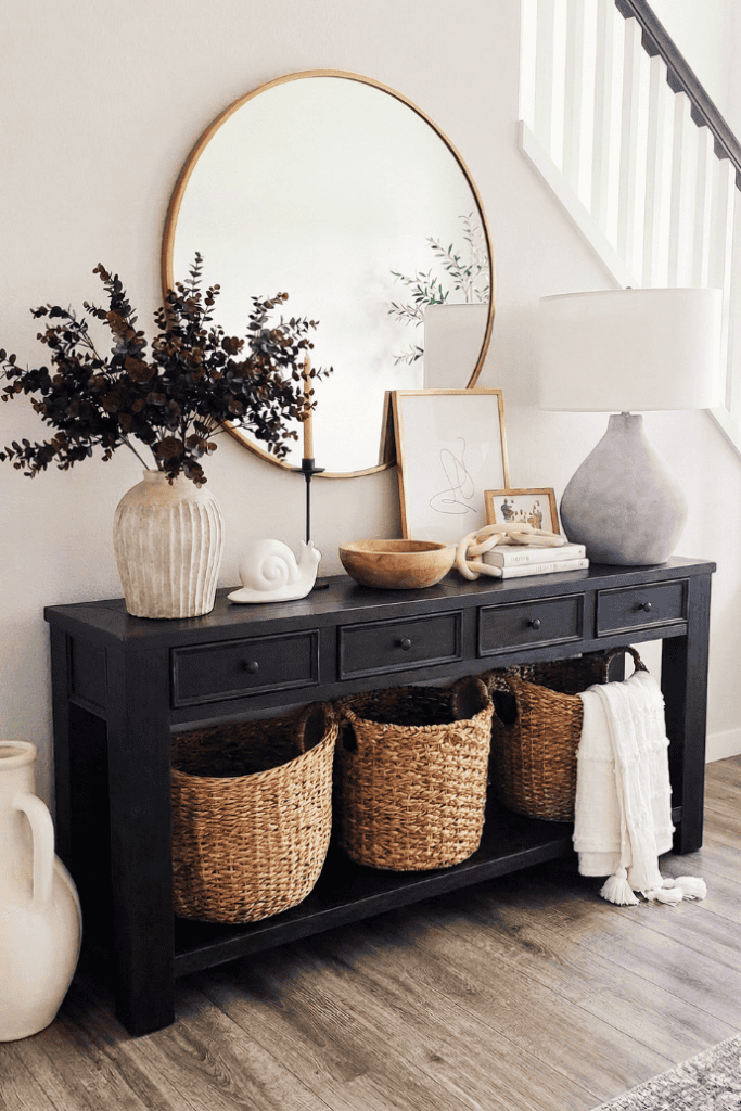 Elegant living room console table with decorative vases, mirror, and woven baskets for stylish home.