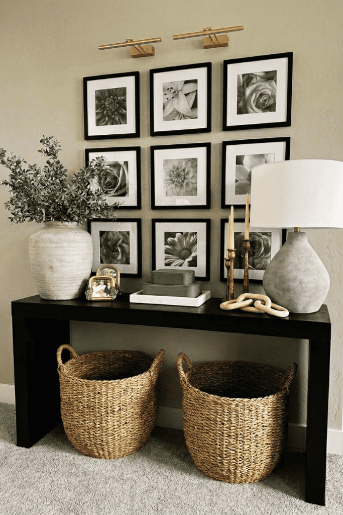 Stylish living room console table decor with black and white floral art, vases, and woven baskets fo.