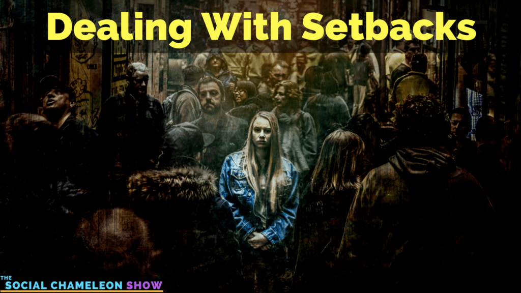 A woman in a denim jacket stands surrounded by a crowd, looking pensive. At the top, "Dealing With Setbacks" captures her contemplation in this bustling scene, while "The Social Chameleon Show" is subtly displayed at the bottom corner. The image conveys resilience amidst life's challenges.