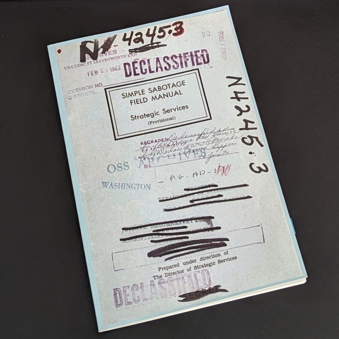 The image depicts a vintage document titled "Simple Sabotage Field Manual" from Strategic Services, dated February 17, 1963. The cover is adorned with multiple "DECLASSIFIED" stamps and handwritten notes, evoking an era where understanding cognitive biases required careful scrutiny of redacted text portions.