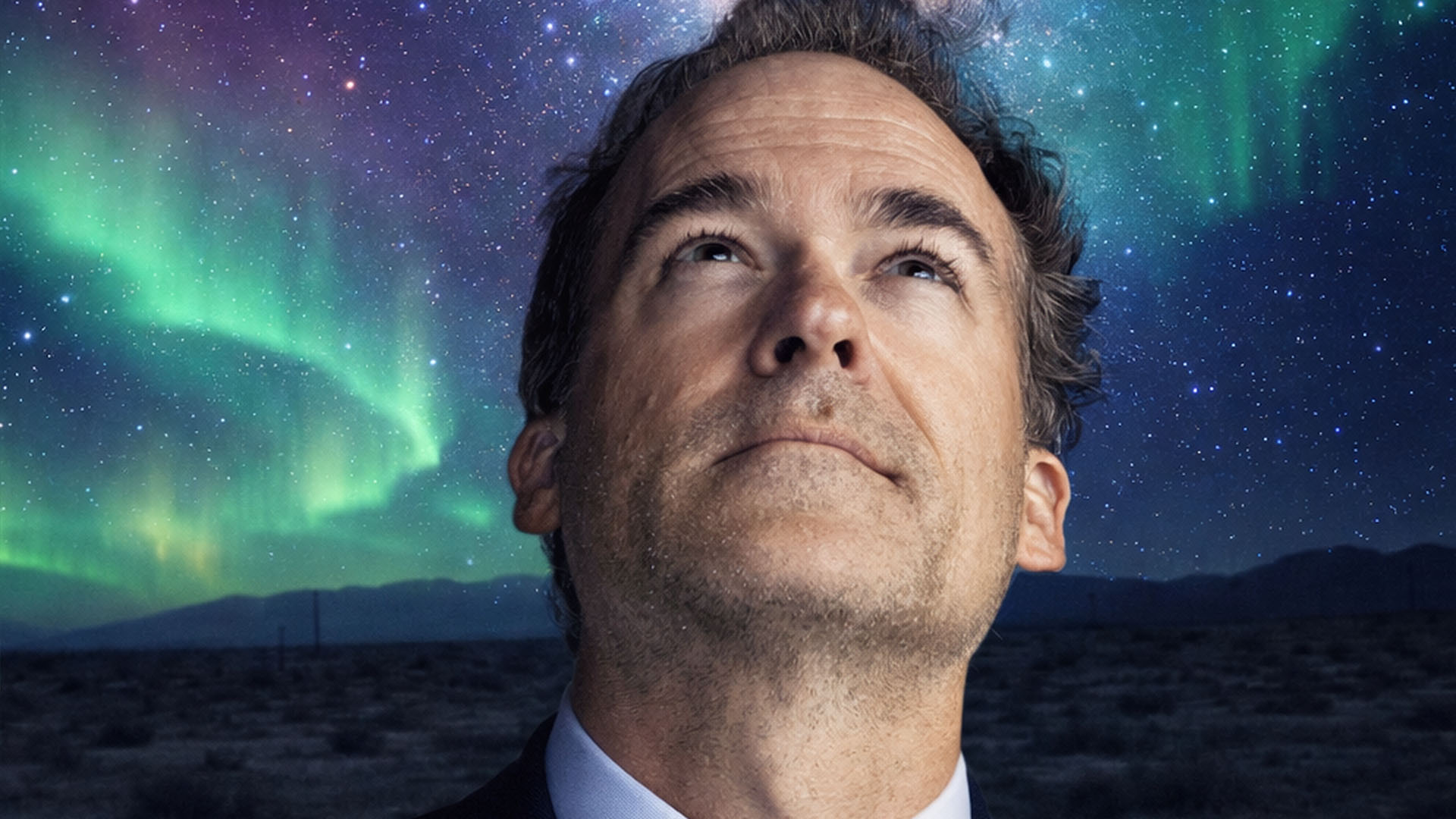 A man gazing up at the vibrant Northern Lights in the night sky, with a starry background and a dark landscape below.