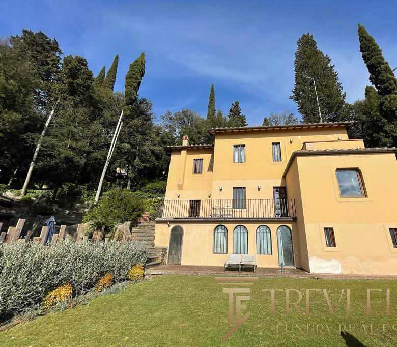 Роскошный дом в Италии возле зелёных деревьев и на фоне голубого неба, идеально подходящий для элитной недвижимости.