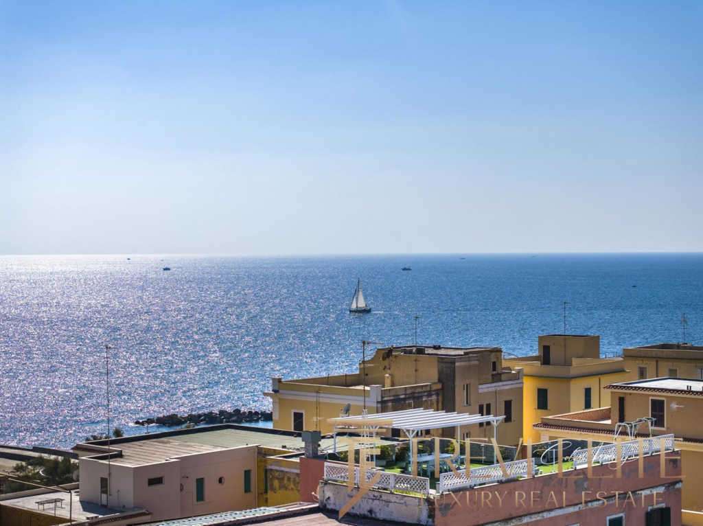 Вид на море и прибрежные дома на солнечном побережье Италии, роскошные апартаменты с террасами и солнечными зонами. Идеальное место для элитной недвижимости и отдыха на море.