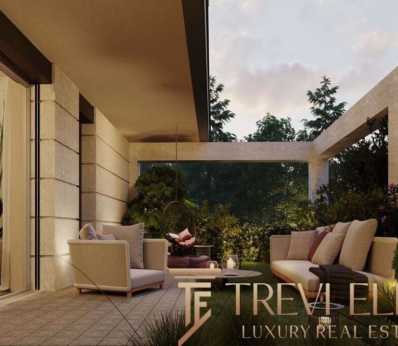 Современная терраса с уютной зоной отдыха и панорамным видом на зелень, сочетающая стильный дизайн и высокое качество материалов в элитной недвижимости.