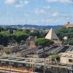 Вид на город с зелеными насаждениями и архитектурными памятниками, в центре фото база железнодорожных путей.