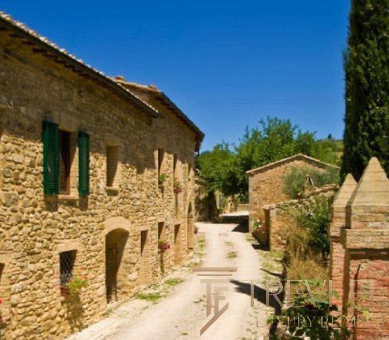 Уютная старинная каменная деревенская улица в итальянской сельской местности с зеленью и цветами.