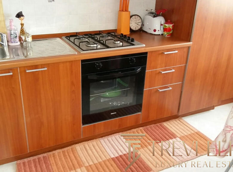 Современная кухня с деревянными фасадами, встроенной плитой и духовкой, раковиной и эстетичным интерьером для комфортной жизни.