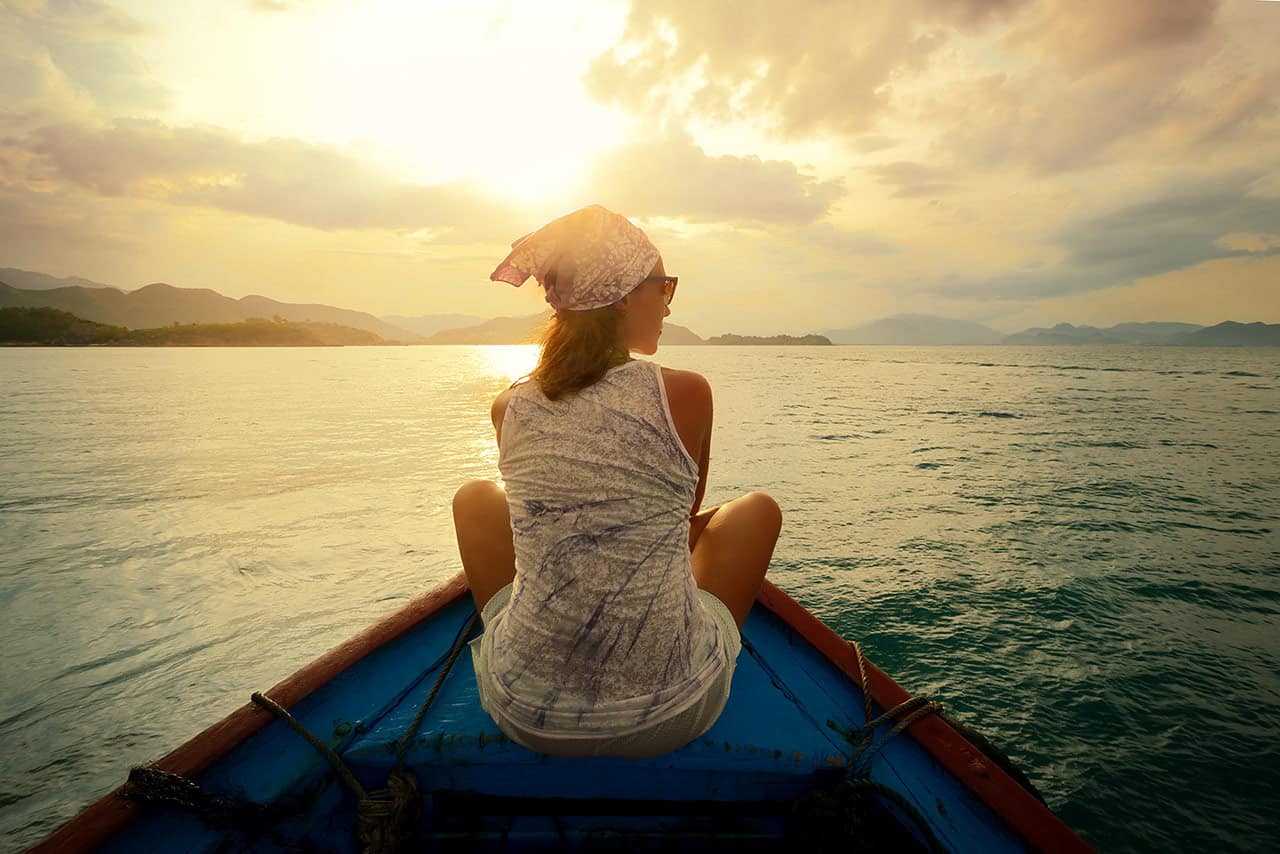 Punta Cana Woman sitting on a boat at sunset in Punta Cana.