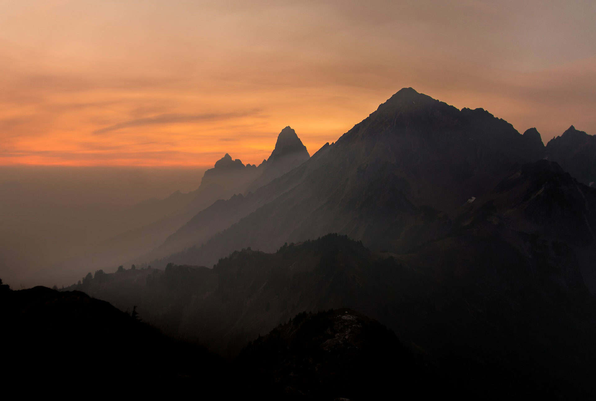 Punta Cana Sunset over rugged mountains with a colorful sky in the background.