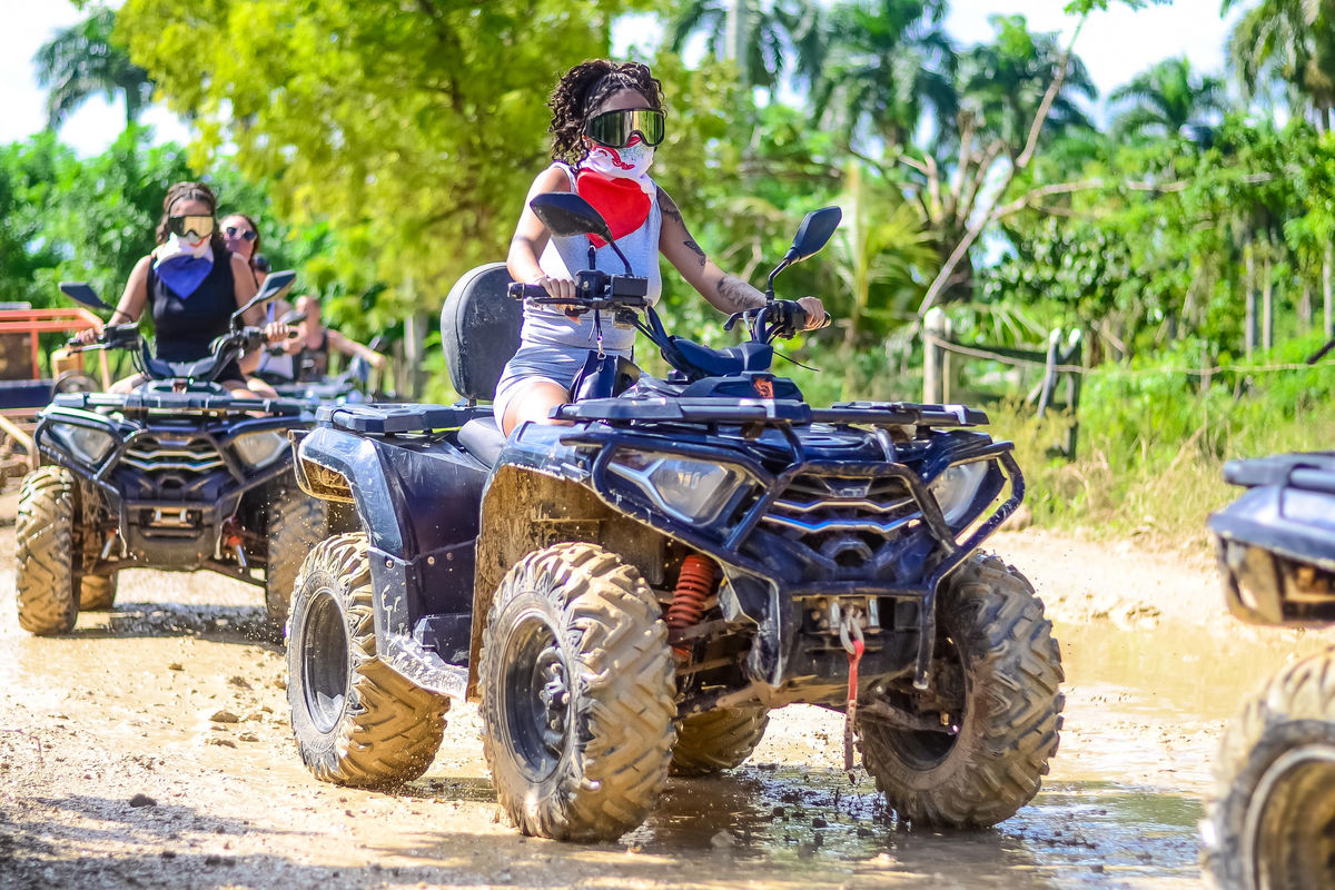 Punta Cana Mujer conduciendo cuatrimoto en sendero de tierra en Punta Cana, República Dominicana.