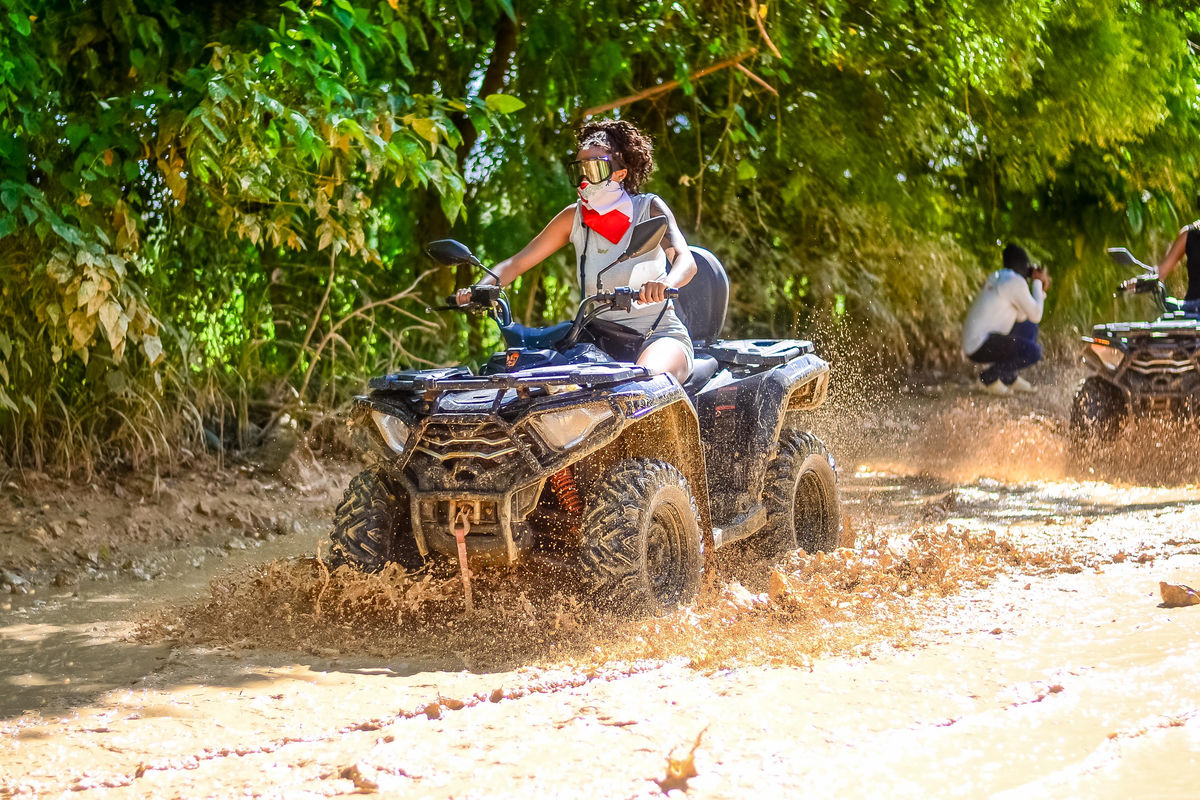 Punta Cana ATV riding through muddy trail with lush greenery in Punta Cana.