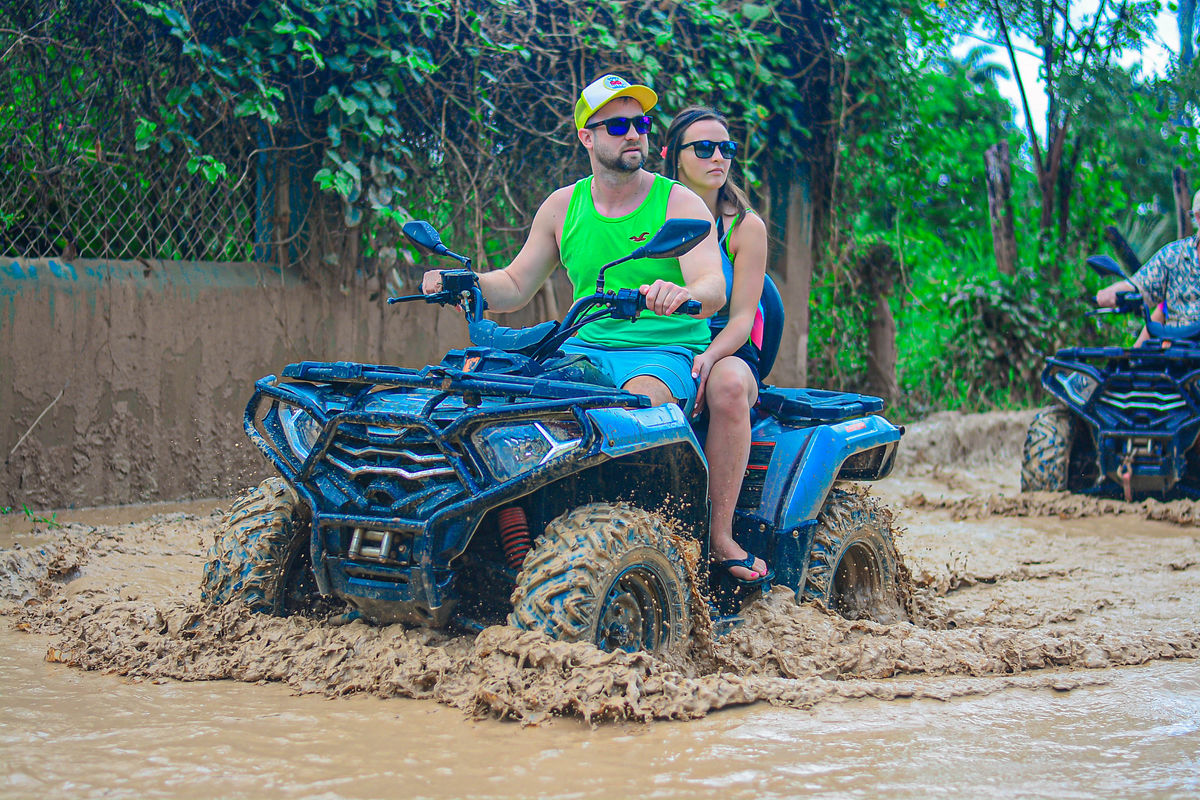 Punta Cana Couple riding an ATV through muddy terrain in Punta Cana, Dominican Republic.