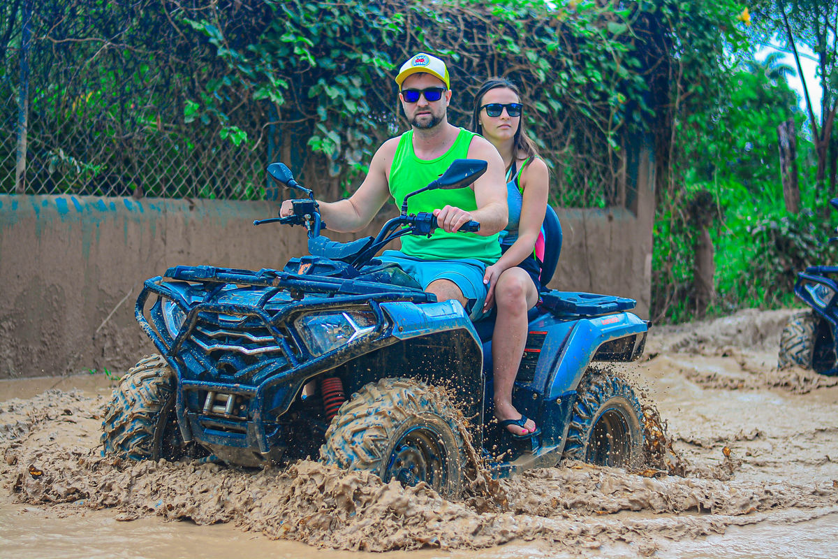 Punta Cana Couple riding an ATV through muddy terrain in Punta Cana, Dominican Republic.