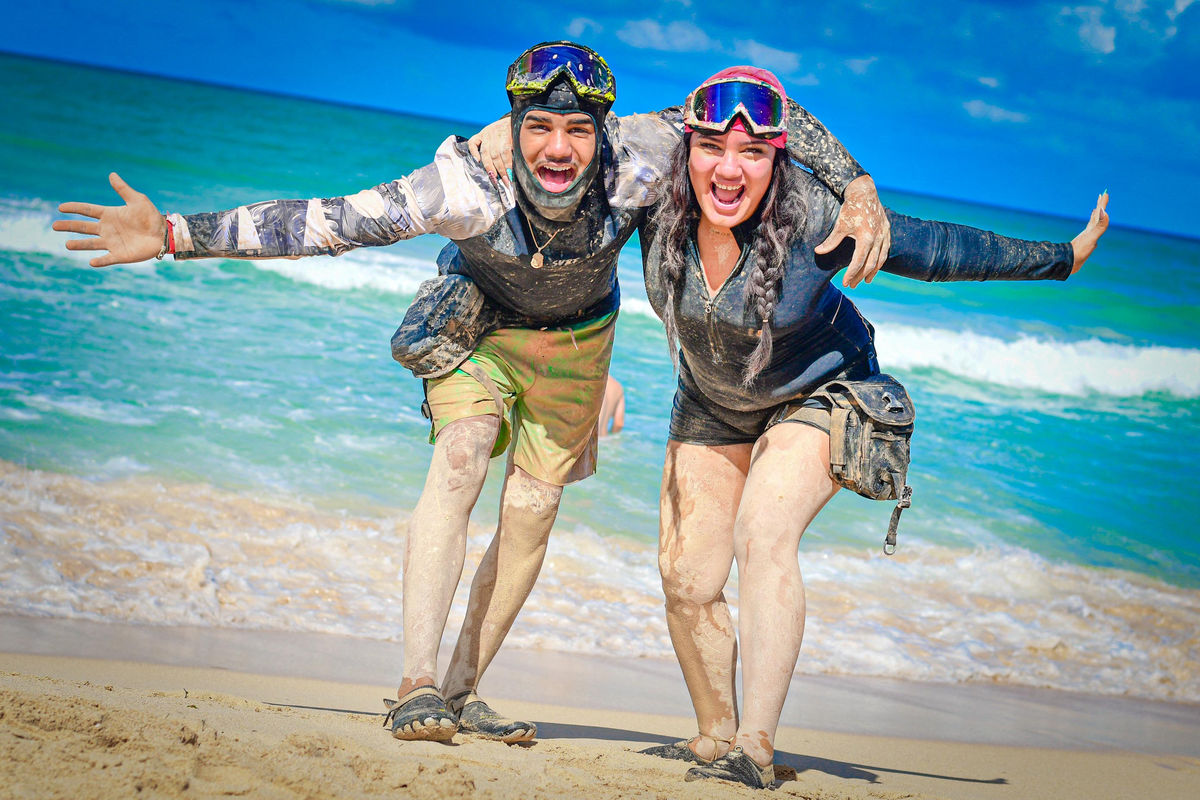 Punta Cana Happy couple with muddy clothes and helmets on the beach in Punta Cana.