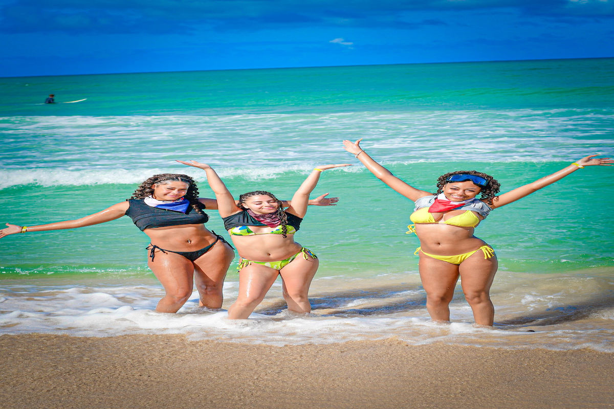Punta Cana Three women enjoying a sunny day at Punta Cana beach in colorful swimsuits.