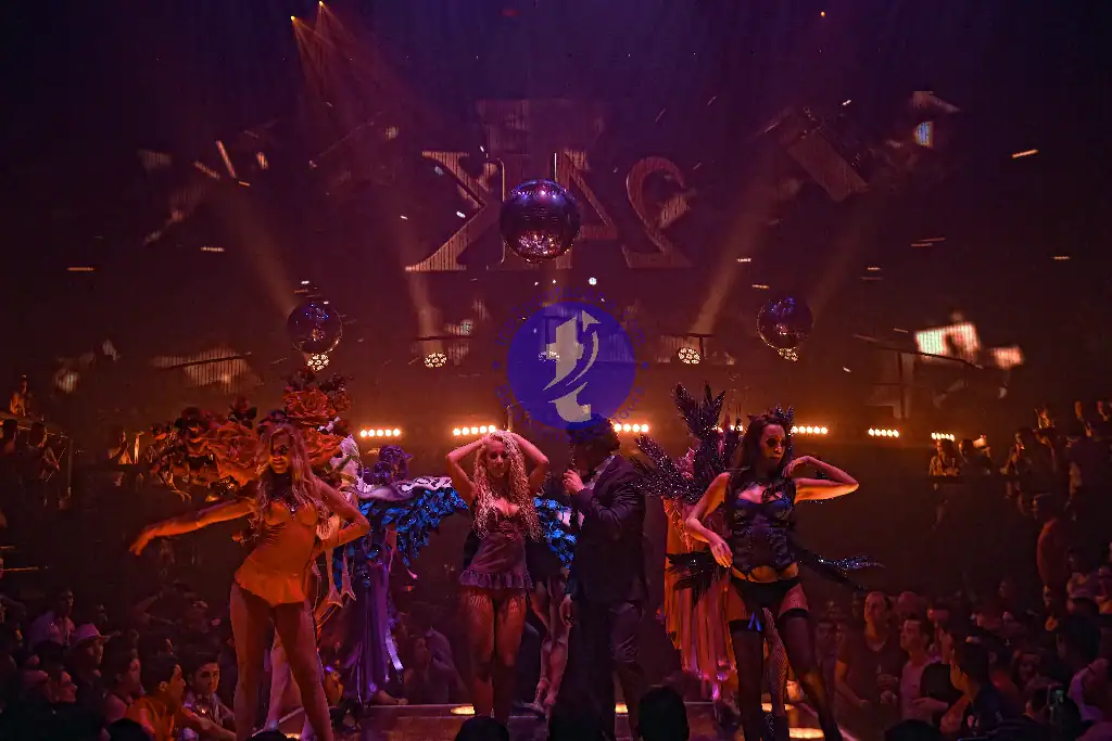 Punta Cana Nightclub dance show with performers in vibrant costumes under colorful lighting.