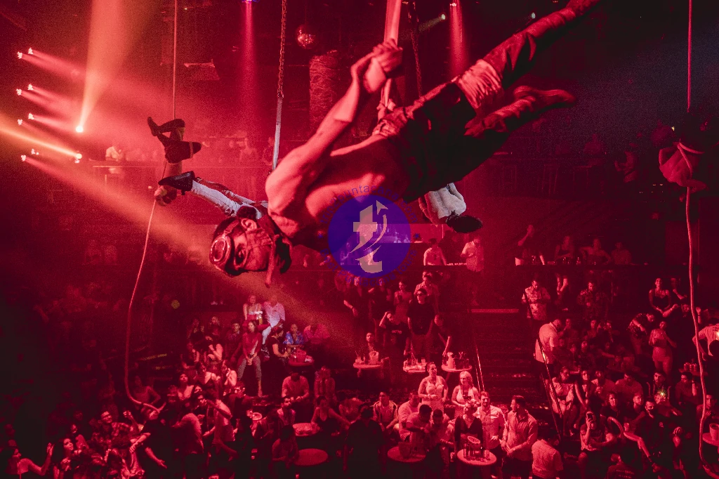 Punta Cana Circus performer in mid-air during a show with audience in the background in Punta Cana.
