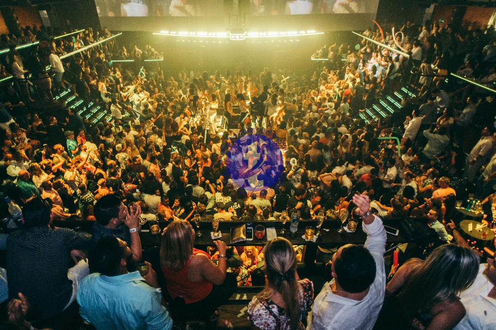 Punta Cana Crowd dancing and enjoying music at a lively nightclub with bright lights and energetic atmosphere.