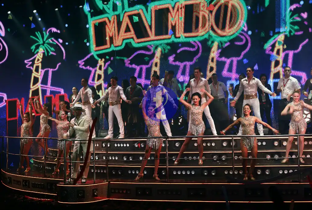 Punta Cana Performers showcase energetic dance moves on stage with colorful tropical backdrop.