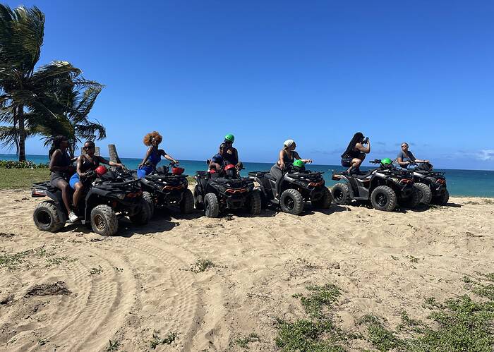 Punta Cana ATV adventure tour in Punta Cana with a group riding quad bikes along the beach.