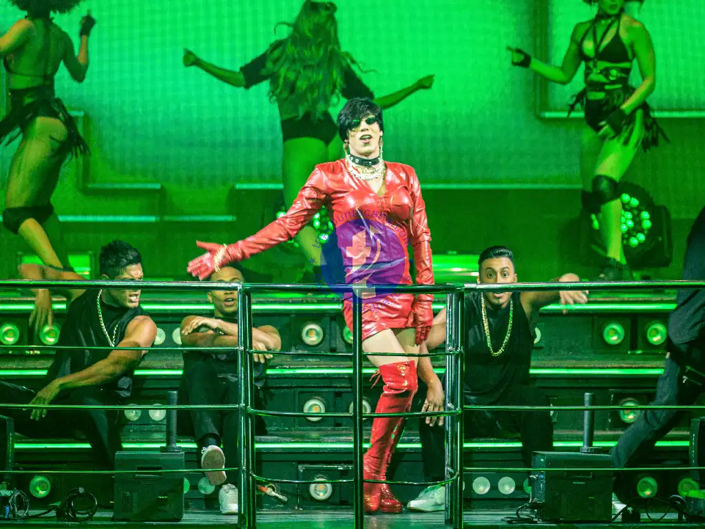 Punta Cana Female singer in red outfit performing with backup dancers on stage.
