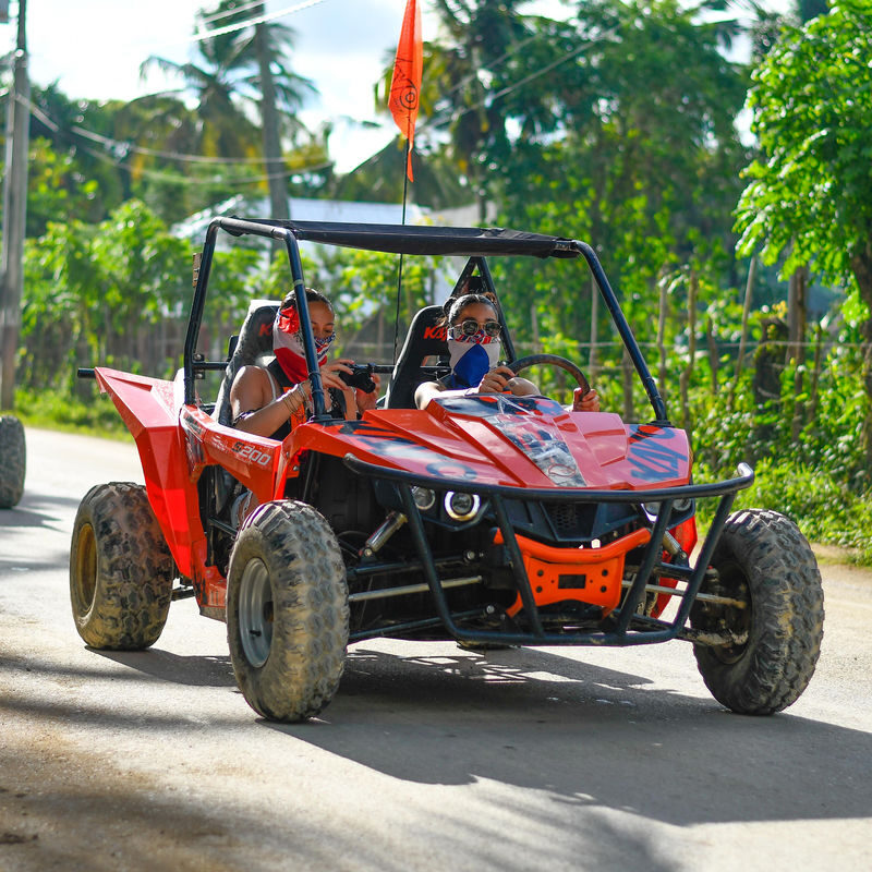 Punta Cana Exciting off-road buggy ride through lush Punta Cana landscape with tourists enjoying the adventure.