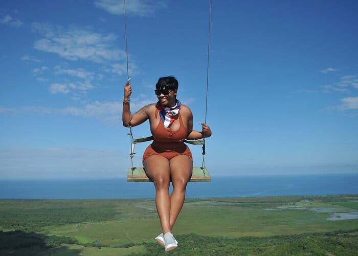 Punta Cana Woman enjoying a scenic swing ride with ocean views in Bavaro, Dominican Republic.