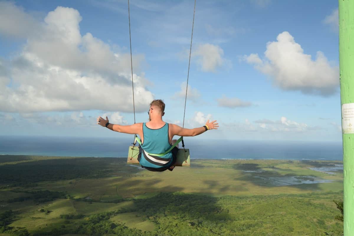 Punta Cana Person enjoying a swing ride with scenic views of the countryside and ocean.