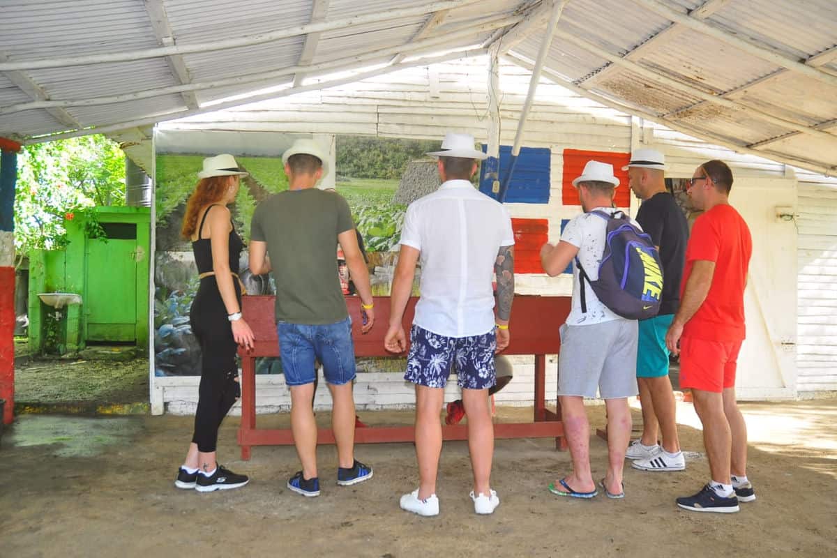 Punta Cana Group of tourists gathered around a table at an outdoor tour location in Bavaro.