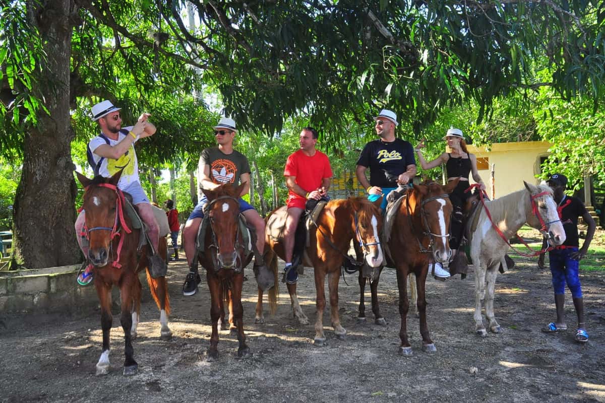 Punta Cana Group of people enjoying horseback riding tour in a scenic outdoor setting.